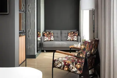 a living room with a couch and a chair at NH Collection Amsterdam Flower Market in Amsterdam