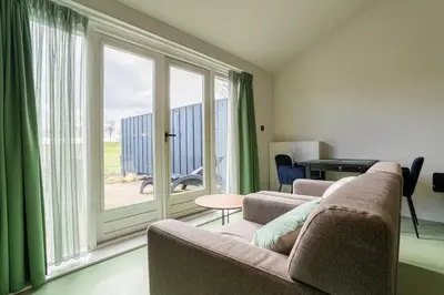 a living room with two couches and a large window at Huize Leeghwater in Zuidoostbeemster