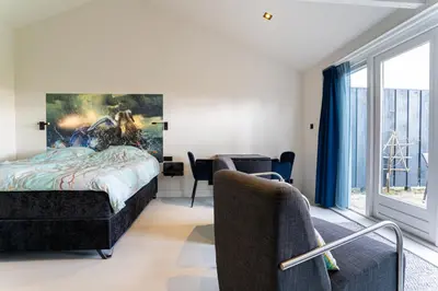 a bedroom with a bed with a painting on the wall at Huize Leeghwater in Zuidoostbeemster