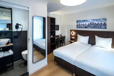 a hotel room with a bed and a bathroom at Hotel Nes Amsterdam in Amsterdam