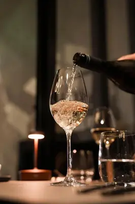 a person is pouring wine into a wine glass at Boutique Hotel Albus Amsterdam Centre in Amsterdam