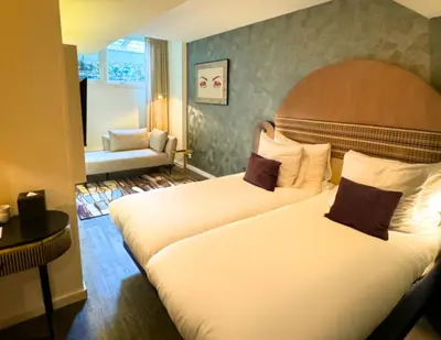 a hotel room with two beds and a couch at Boutique Hotel Albus Amsterdam Centre in Amsterdam