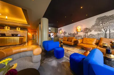 a lobby with blue and orange furniture and a mural at Boutique Hotel Albus Amsterdam Centre in Amsterdam