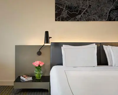 a bedroom with a bed with a vase of flowers on a table at Park Plaza Victoria Amsterdam in Amsterdam