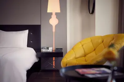a bedroom with a bed and a yellow chair at Park Plaza Victoria Amsterdam in Amsterdam
