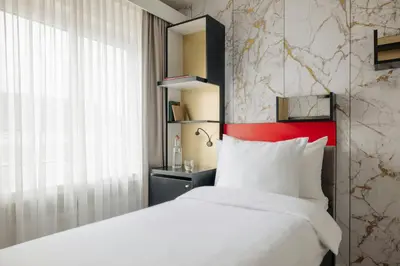 a bedroom with a white bed and a red headboard at Leonardo Boutique Hotel The Lancaster Amsterdam in Amsterdam