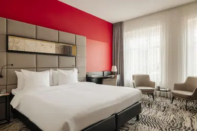 a hotel room with a large bed and a red wall at Leonardo Boutique Hotel The Lancaster Amsterdam in Amsterdam