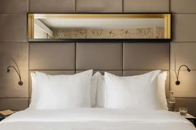 a bed with white pillows and a mirror above it at Leonardo Boutique Hotel The Lancaster Amsterdam in Amsterdam