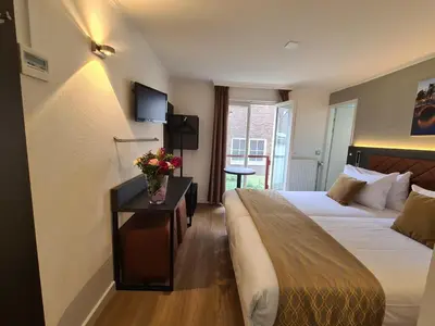 a hotel room with two beds and flowers on a table at Avenue Hotel in Amsterdam