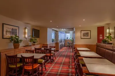 a dining room with tables and chairs in a restaurant at Avenue Hotel in Amsterdam