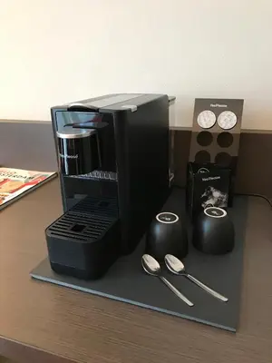 a desk with a coffee maker and a box and spoons at Avenue Hotel in Amsterdam