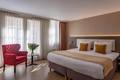 a hotel room with a large bed and a red chair at Avenue Hotel in Amsterdam