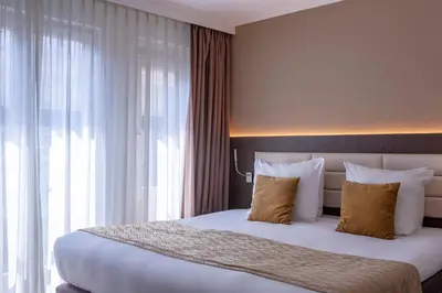 a bedroom with a large bed with a large window at Avenue Hotel in Amsterdam