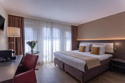 a hotel room with a bed and a desk and a computer at Avenue Hotel in Amsterdam