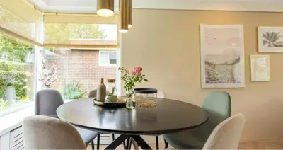 a dining room with a table and chairs at VT wonen stijl vakantiebungalow nabij zee, strand, bos en duinen voor 6 personen in Warmenhuizen