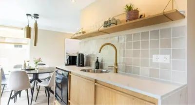 a kitchen with a sink and a table with chairs at VT wonen stijl vakantiebungalow nabij zee, strand, bos en duinen voor 6 personen in Warmenhuizen