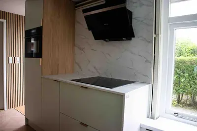 a kitchen with a counter top and a window at VT wonen stijl vakantiebungalow nabij zee, strand, bos en duinen voor 6 personen in Warmenhuizen