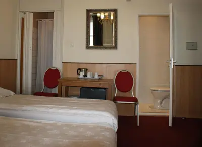 a hotel room with a bed and a table and chairs at Hotel de Westertoren in Amsterdam