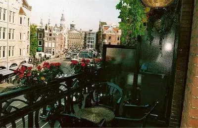 a balcony with chairs and a view of a city at Hotel de Westertoren in Amsterdam