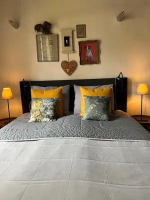 a large bed in a bedroom with two lamps at B&B De Kamer Hiernaast in Gouda