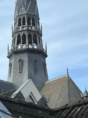 a church steeple with a clock tower on top of a roof at B&B De Kamer Hiernaast in Gouda
