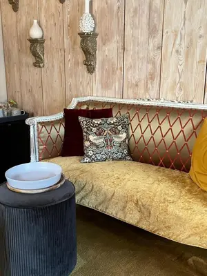 a couch with a table in a room with wooden walls at B&B De Kamer Hiernaast in Gouda