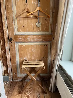 a wooden door with a wooden stool in a room at B&B De Kamer Hiernaast in Gouda