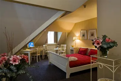 a room with a bed and a table with a laptop at Amrâth Hotel Lapershoek Arenapark in Hilversum