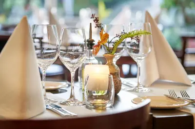 a table with wine glasses and a candle on it at Amrâth Hotel Lapershoek Arenapark in Hilversum
