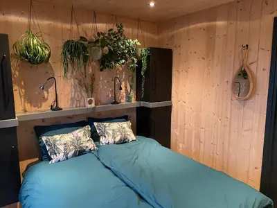 a bed in a room with plants on the wall at GreenFloat Boskoop #2 Mica & Luca in Boskoop