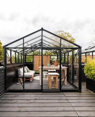 a greenhouse on a deck with a table and a bench at GreenFloat Boskoop #2 Mica & Luca in Boskoop