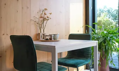 a white table with two green chairs around it at GreenFloat Boskoop #2 Mica & Luca in Boskoop