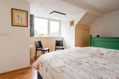 a bedroom with a bed and two chairs in it at Huisje Marie Loosdrecht in Loosdrecht