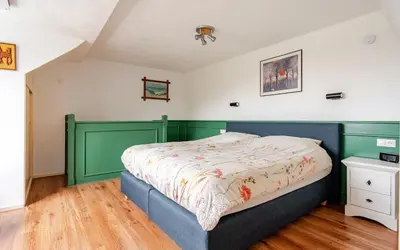 a bedroom with a bed with a green headboard at Huisje Marie Loosdrecht in Loosdrecht