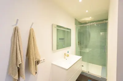 a white bathroom with a sink and a shower at Spacious and attractive family home near Amsterdam in Overveen