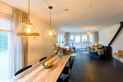 a living room with a long wooden table and chairs at Spacious and attractive family home near Amsterdam in Overveen