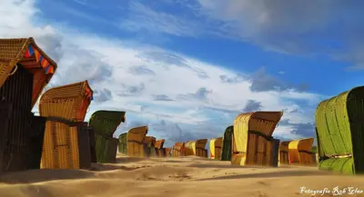 a painting of a desert with chairs in the sand at Glücklich am Meer Apartment Deluxe mit Wellnesszugang in Egmond aan Zee