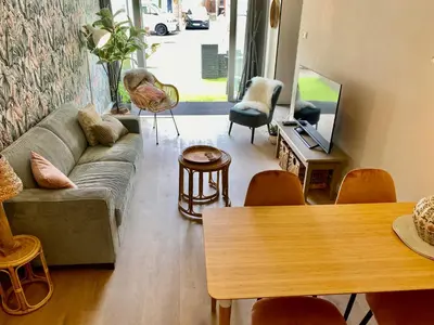 a living room with a couch and a table at Glücklich am Meer Apartment Deluxe mit Wellnesszugang in Egmond aan Zee