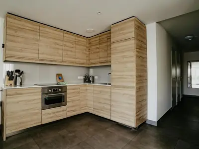 a kitchen with wooden cabinets and a stove at Waterside Escape with Easy Access in Uitgeest