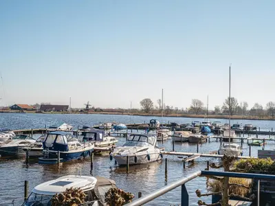 a bunch of boats are docked in the water at Waterside Escape with Easy Access in Uitgeest