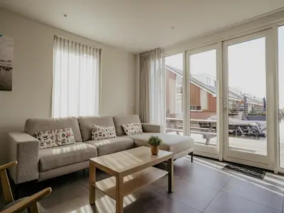 a living room with a couch and a table at Waterside Escape with Easy Access in Uitgeest