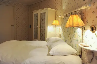 a bedroom with a bed and a lamp and a sink at Imperial Hotel Amsterdam in Amsterdam