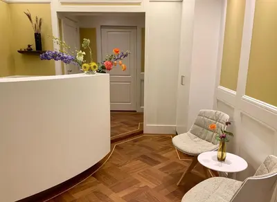 a hallway with two chairs and a table and flowers at Imperial Hotel Amsterdam in Amsterdam