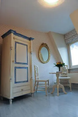 a room with a cabinet and a table and a mirror at Imperial Hotel Amsterdam in Amsterdam