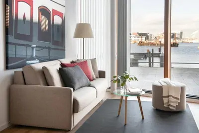 a living room with a couch and a large window at Eric Vökel Boutique Apartments - Riverfront Suites in Amsterdam