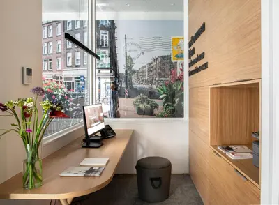 an office with a desk and a window with flowers at Eric Vökel Boutique Apartments - Riverfront Suites in Amsterdam