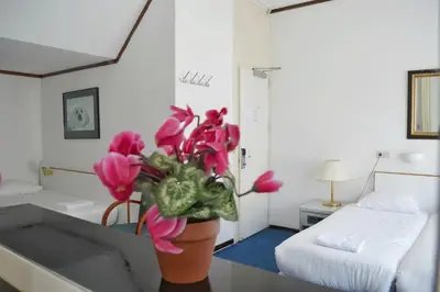 a room with a vase with pink flowers on a table at Hotel de Munck in Amsterdam