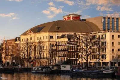 a large building with a dome on top next to a river at Hotel de Munck in Amsterdam