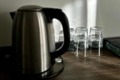 a tea kettle and three empty glasses on a table at Hotel de Munck in Amsterdam