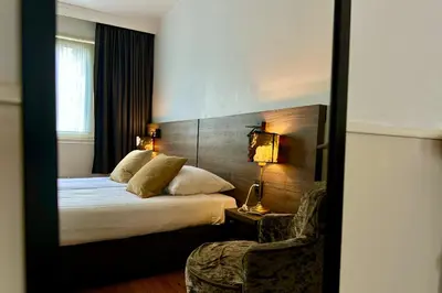 a hotel room with a bed and a mirror at Hotel de Munck in Amsterdam